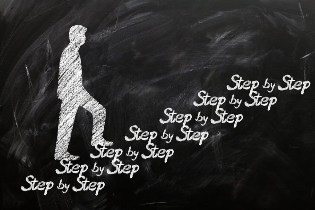Step by Stepと書かれた階段をのぼる男性のイラスト