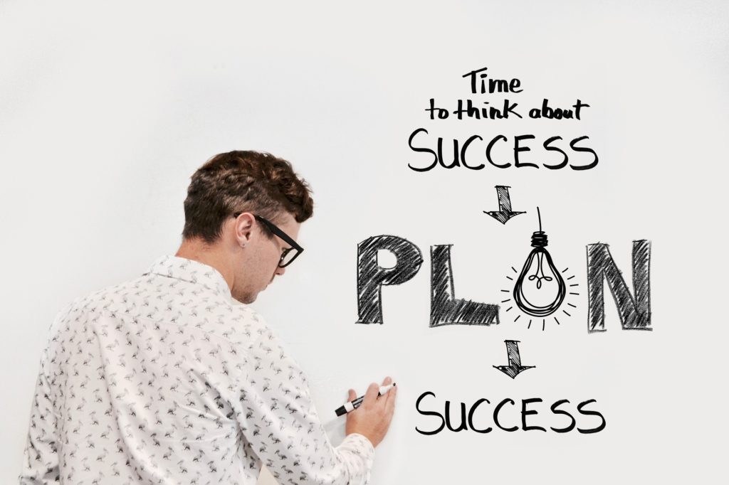 「計画」→「成功」を書く男性