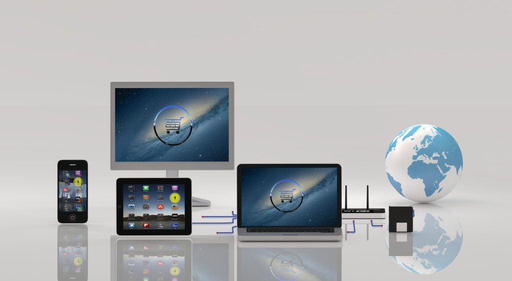 2台のパソコンやタブレット、スマートフォンの画面と地球のイラスト
